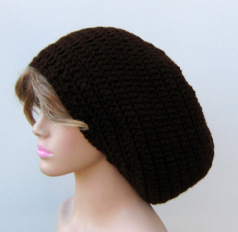 May include: A brown crocheted beanie hat. The hat is large and loose fitting, with a slouchy style.