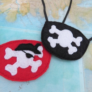 May include: Two felt pirate eye patches with elastic straps. One patch is red with a white skull and crossbones design. The other patch is black with a white skull and crossbones design.
