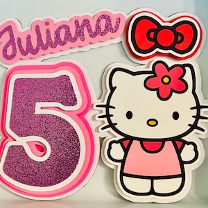 May include: Pink and purple glitter cake topper with the name "Juliana" and the number "5" with a pink Hello Kitty character.