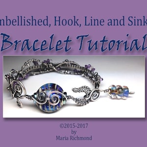 Op de afbeelding: Een zilveren draadgewikkelde armband met een blauw-wit gestreepte glazen kraal en een bedel van zilverdraad. De armband heeft ook kleine paarse glazen kralen. De tekst "Embellished, Hook, Line and Sinker Bracelet Tutorial ©2015-2017 by Maria Richmond" is zichtbaar onder de armband.