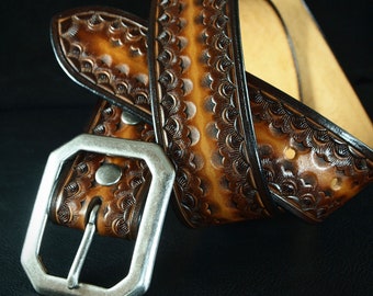 May include: A brown leather belt with a silver buckle. The belt has a decorative pattern of overlapping circles.