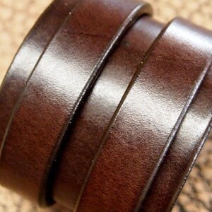 May include: A brown leather bracelet with multiple layers of leather. The bracelet is made of a thick, durable leather and has a simple, elegant design.