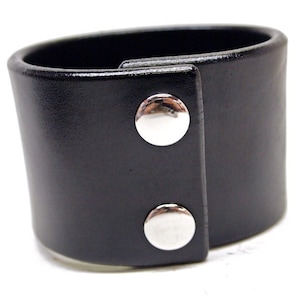 May include: Black leather cuff bracelet with two silver snap closures.