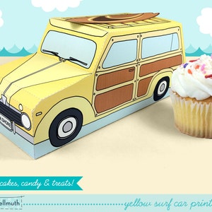 Pode incluir: Um kit imprimível para um carro de papelão amarelo em forma de vagão de estação vintage com uma prancha de surf no topo. O carro é projetado para conter cupcakes, doces ou guloseimas. O texto "yellow surf car printable kit" está impresso na parte inferior da imagem.