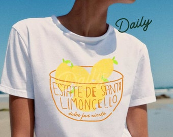 May include: White t-shirt featuring a graphic of lemons in a bowl with the text "ESTATE DE SANTO LIMONCELLO" in orange. The shirt also has the word "Daily" in green. The design is reminiscent of a vintage advertisement.
