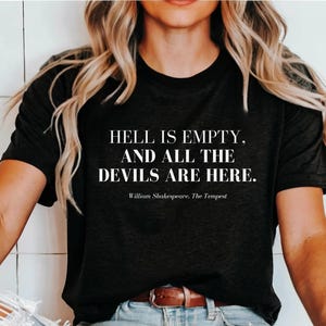 May include: Black t-shirt with white text that reads "HELL IS EMPTY. AND ALL THE DEVILS ARE HERE. William Shakespeare. The Tempest"