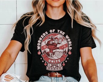 May include: A black t-shirt with a red and white graphic of Santa Claus climbing a chimney. The graphic includes the text "Workers of the World Unite" and "Ho Ho Ho".