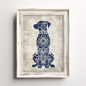 K&ouml;nnte beinhalten: Eine blaue und wei&szlig;e, gemusterte Hundesilhouette in einem wei&szlig;en Rahmen. Der Hund sitzt mit dem Kopf zur Seite gedreht. Der Hintergrund ist hellbeige.