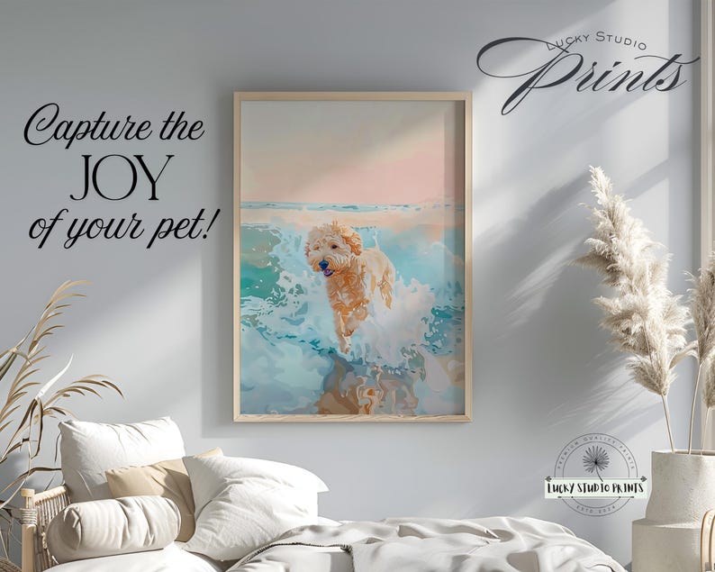 May include: A framed print featuring a golden doodle dog playing in ocean waves. The artwork has a watercolor style with a light pink and blue color palette. Text on the print reads "Capture the JOY of your pet!" and "Lucky Studio Prints".