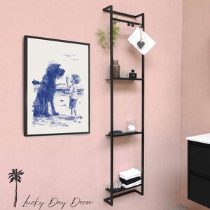 a bathroom with a pink wall and black shelving unit