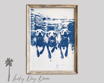 May include: A framed print of three dogs swimming underwater. The dogs are silhouetted in blue against a white background. The print has a rustic wood frame.