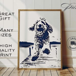 May include: A framed print featuring a black and white illustration of a dog leaping off a dock. The artwork has a minimalist style with a navy blue lake and sky background. Text on the print reads "GREAT GIFT", "MANY SIZES", and "HIGH QUALITY PRINT".