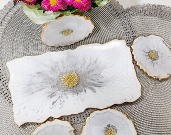 Set of white resin coasters with gold stones and gold trim.