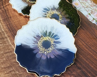 A set of black and white coasters made of epoxy resin with black stones, decorated with gold inserts, handmade.