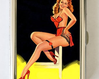 May include: A vintage style cigarette case featuring a pin-up girl wearing a red lingerie set and high heels. The background is black with a yellow spotlight.