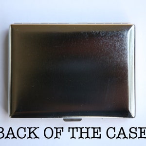 May include: The back of a silver cigarette case. The case is smooth and has a slight sheen.