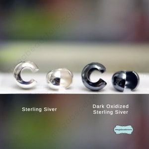 May include: Four silver bead caps, two in a shiny finish and two in a dark oxidized finish. The caps are open on one side and have a round shape. The text "Sterling Silver" is below the shiny caps and "Dark Oxidized Sterling Silver" is below the oxidized caps.