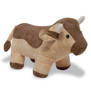 Può includere: Un giocattolo di peluche di mucca trapuntato marrone e beige. La mucca ha il naso marrone, gli occhi neri e le corna bianche.