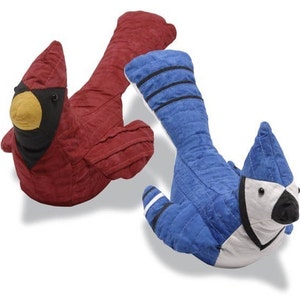 Könnte beinhalten: Zwei plüschige Vogel-Türstopper, ein roter Kardinal und ein blauer Jay. Der Kardinal hat einen schwarzen Kopf und einen gelben Schnabel. Der Blaue Jay hat einen weißen Kopf und einen schwarzen Schnabel.