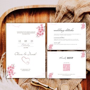 May include: Wedding invitation with a pink cherry blossom design. The invitation includes the date, time, and location of the wedding. It also includes a QR code for RSVP.