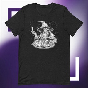 May include: A black t-shirt featuring a white illustration of a wizard holding a pizza and a fork. The wizard has a long white beard and is wearing a pointed hat. The background is a starry night sky.