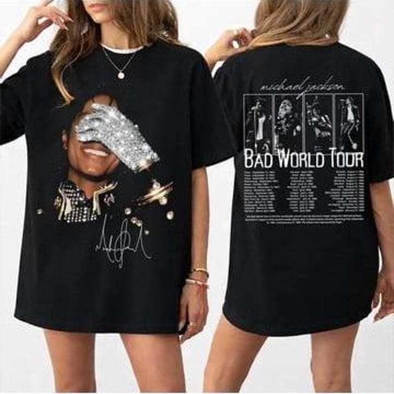 May include: Black t-shirt featuring a graphic of Michael Jackson with a sequined glove covering his face. The front of the shirt includes his signature and other design elements. The back of the shirt displays "Michael Jackson Bad World Tour" text and images.