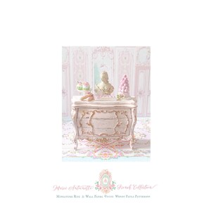 May include: A miniature light pink chest of drawers with gold-toned ornate detailing. On top sits a small bust, a pink macaron tower, two cupcakes, and two eclairs. The text reads: Marie Antoinette French Collection Miniature Rug & Wall Panel.