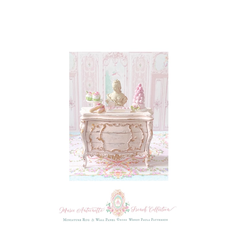 May include: A miniature light pink chest of drawers with gold-toned ornate detailing. On top sits a small bust, a pink macaron tower, two cupcakes, and two eclairs. The text reads: Marie Antoinette French Collection Miniature Rug & Wall Panel.