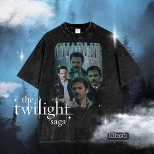 May include: Black t-shirt with a vintage-style graphic of Charlie Swan from The Twilight Saga. The design includes multiple images of the character and the text "CHARLIE Swan". The shirt also has the text "the twilight saga" and the word "Black".