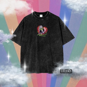 Puede incluir: Camiseta negra de gran tamaño con un lavado desgastado. La camiseta presenta un gráfico de dibujos animados de un personaje dentro de un corazón con el texto "I am just an evil little bitch". La palabra "Black" se muestra en un cuadro blanco.