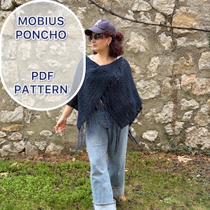 Może przedstawiać: Granatowe poncho Mobius z frędzlami. Poncho jest częścią wzoru PDF. Obraz przedstawia poncho noszone z niebieskimi dżinsami i czarnymi butami. Tło to kamienna ściana i zielona trawa.