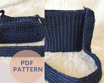 May include: A navy blue crocheted shoulder bag with a long strap. The bag is made with a simple stitch pattern and has a  "PDF PATTERN" label on the front.
