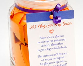 May include: A glass jar filled with orange paper slips, tied with a purple ribbon and a tag that reads "365 Hugs for My Sister". The tag has a poem about the special bond between sisters.