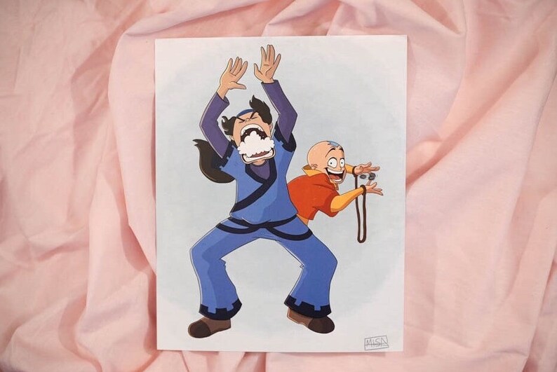 Pu&ograve; includere: Un'illustrazione di cartoni animati di due personaggi della serie animata Avatar: La leggenda di Aang. Il personaggio a sinistra indossa un abito blu e ha le braccia alzate in aria. Il personaggio a destra indossa un abito arancione e ha le braccia distese. Lo sfondo &egrave; di colore blu chiaro.