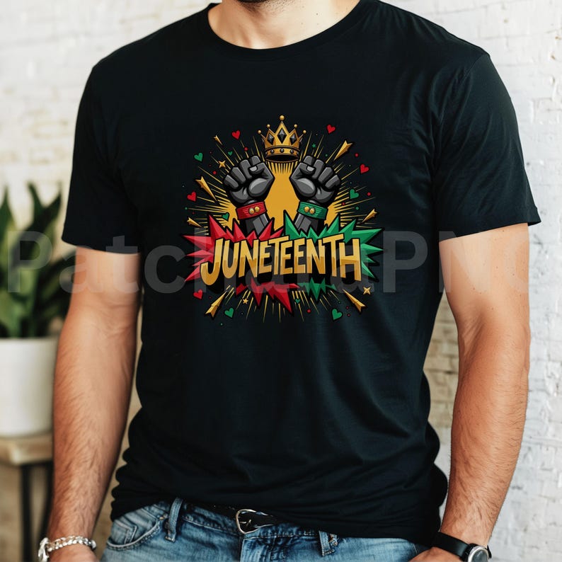 May include: Black t-shirt featuring a graphic design with the word "Juneteenth" in red, green, and gold. The design includes two raised fists, a gold crown, and colorful accents. The shirt is made of a soft material.