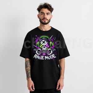 May include: Black t-shirt featuring a graphic of a skull wearing headphones and holding a game controller. The skull has a cross for an eye and the text "RAGE MODE" is below the skull in white letters.