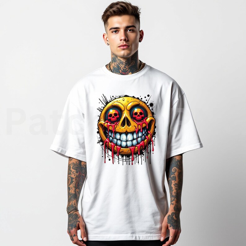 May include: White t-shirt featuring a yellow smiley face with skull eyes and a wide, toothy grin. Red blood-like drips cascade from the face, with black splatter details. The graphic is centered on the shirt.