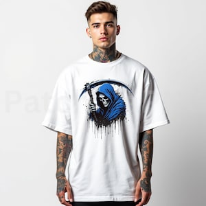 May include: White t-shirt featuring a graphic of the Grim Reaper in a blue hooded cloak, holding a scythe. The design includes black splatter effects. The shirt is a casual, short-sleeved style.