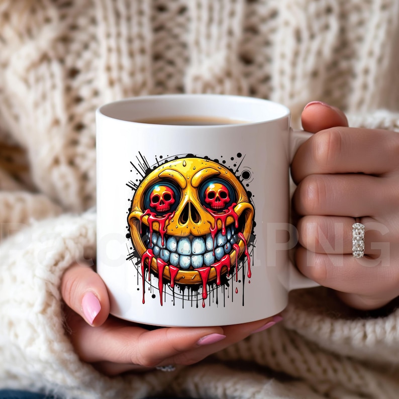 May include: White ceramic mug featuring a yellow, skull-faced emoji with red eyes and dripping blood. The design includes a wide, toothy grin and black splatter details, creating a spooky, Halloween-themed aesthetic. The mug is held by a person.