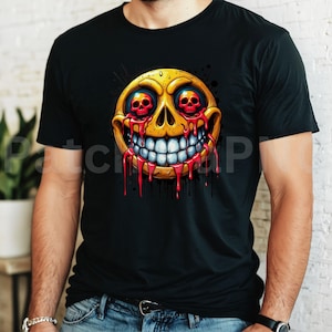 May include: Black t-shirt featuring a yellow, skull-like emoji with red eyes and dripping blood. The emoji has a wide, toothy grin. The design is a graphic illustration, perfect for Halloween or anyone who enjoys unique, edgy apparel.