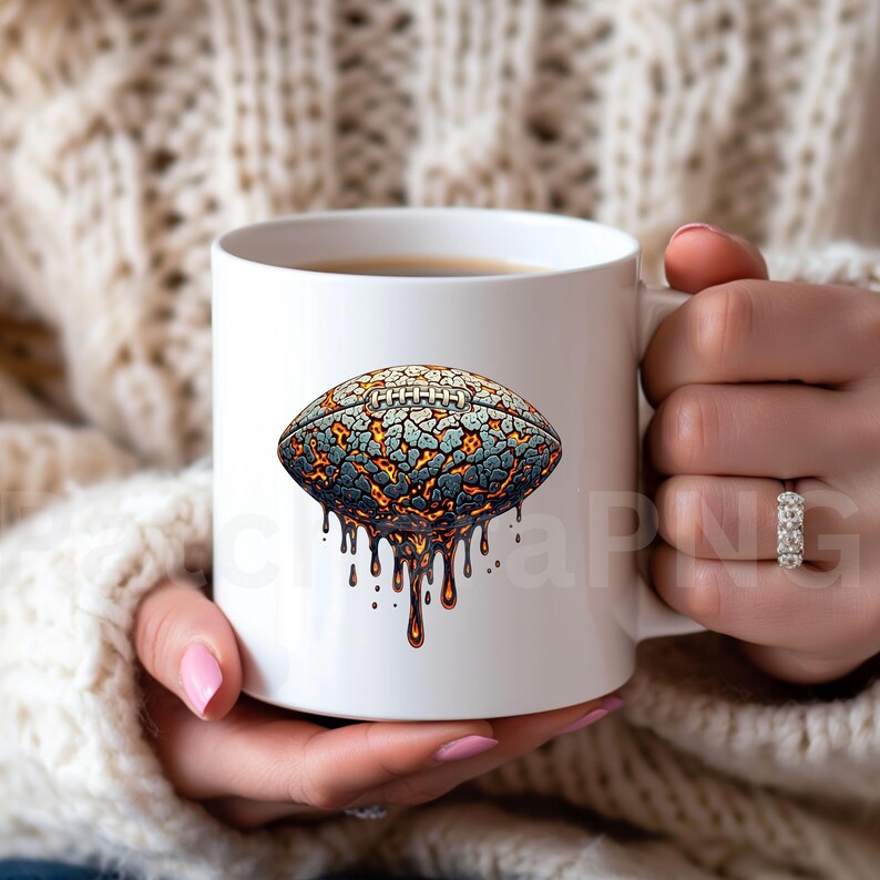 K&ouml;nnte beinhalten: Wei&szlig;e Keramiktasse mit einem stilisierten American-Football-Design. Das Design zeigt eine rissige, strukturierte Oberfl&auml;che in Grau, Blau und Orange mit tropfenden, geschmolzenen Elementen. Die Tasse wird von einer Person gehalten.
