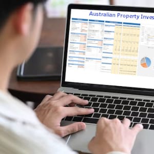 May include: A person is working on a laptop computer. The screen displays a spreadsheet titled "Australian Property Investing" with charts and graphs.