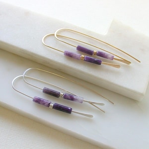 May include: Two pairs of earrings with purple and white stone beads and gold and silver wire.