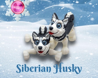 May include: Two adorable black and white Siberian Husky puppies playing in the snow. The puppies are made of fondant and are perfect for a cake topper or decoration.