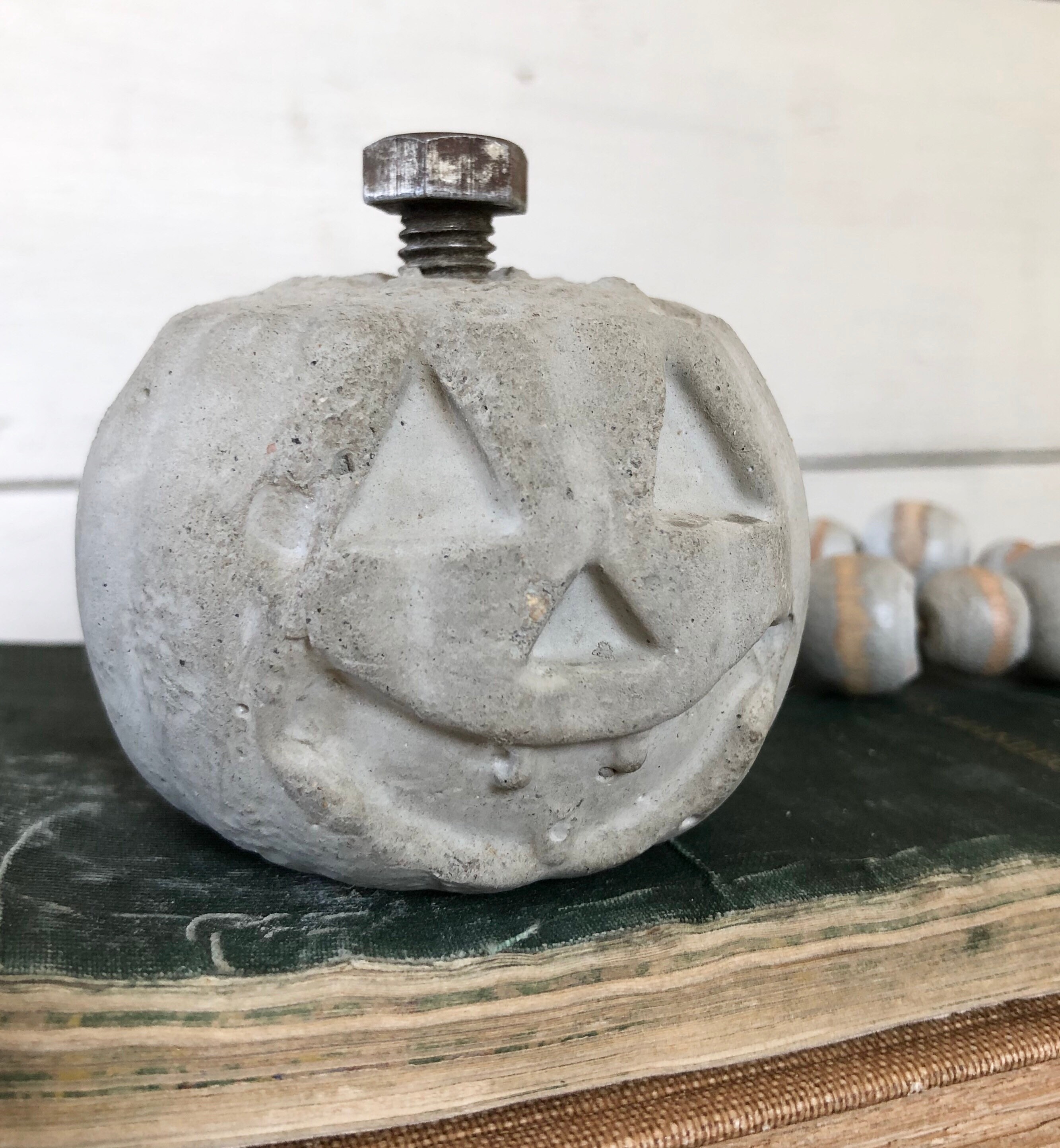 Small Concrete Pumpkin Halloween jackolantern with rusty bolt stem