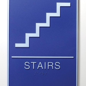 May include: Blue sign with a white staircase symbol and the word "STAIRS" in white text below. Braille dots are below the word "STAIRS".