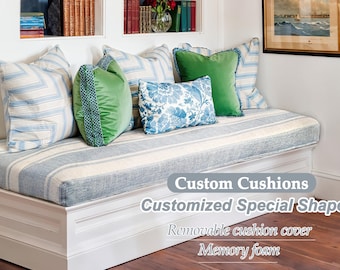 May include: A white window seat with blue and white striped cushions, green velvet cushions, and a blue and white floral cushion. The seat has a white wooden frame and a blue and white striped fabric covering. The text "Custom Cushions Customized Special Shape Removable cushion cover Memory foam" is printed on the seat.