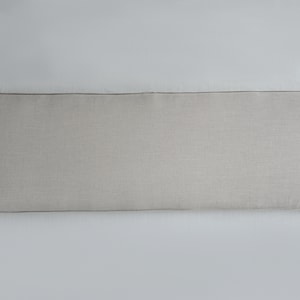 Puede incluir: Un coj&iacute;n rectangular gris claro para cabecero con ribete marr&oacute;n oscuro. El cabecero est&aacute; hecho de una tela texturizada y est&aacute; dise&ntilde;ado para colocarse contra una pared. El coj&iacute;n es largo y estrecho, adecuado para una cama.