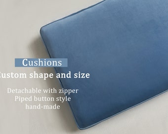 Peut inclure: Un coussin en velours bleu avec des bords passepoilés et une fermeture éclair. Le texte sur l'image indique : Cushions, Custom shape and size, Detachable with zipper, Piped button style, hand-made. Le coussin est de forme rectangulaire.