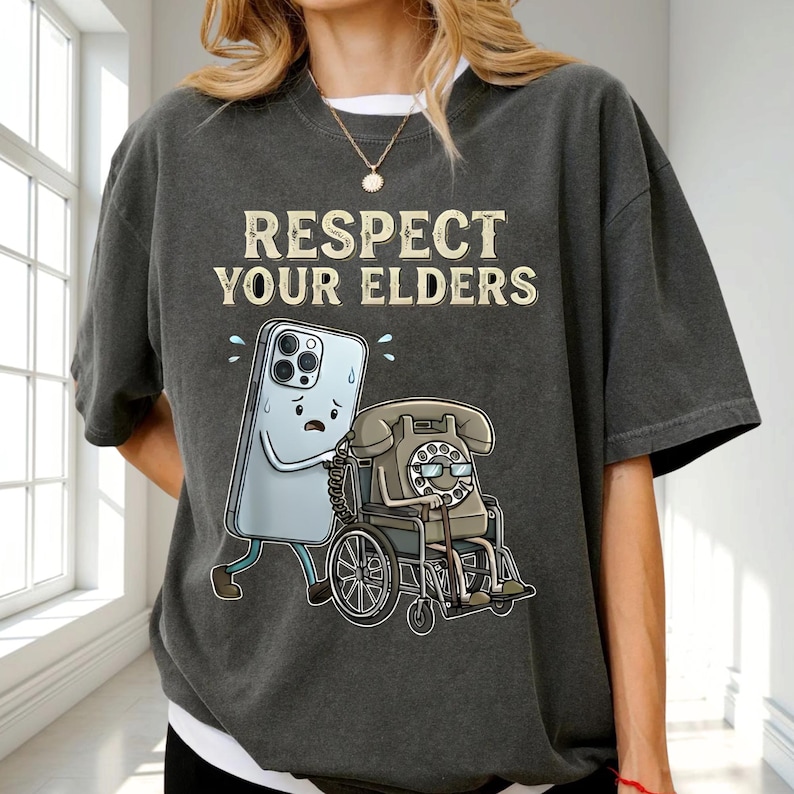 a person wearing a gray t-shirt with a graphic design depicting a phone and a wheelchair.